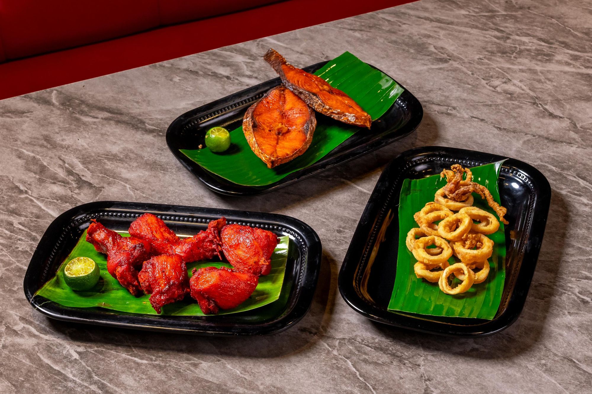 Fish fry, chicken fry and fried calamari on banana leaf